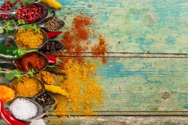 Ahşap masada çeşitli renkli baharatlar var.