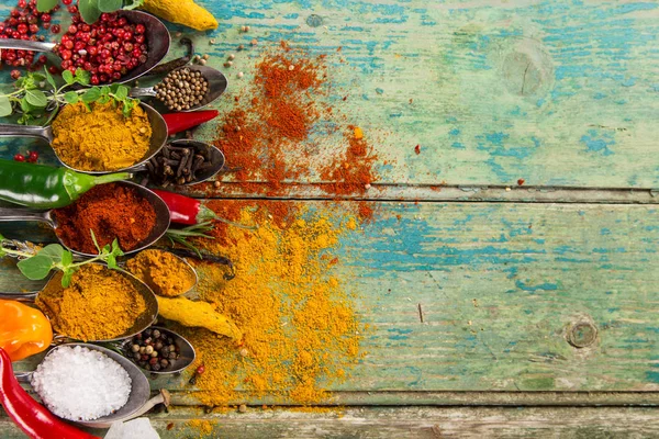 Ahşap masada çeşitli renkli baharatlar var.