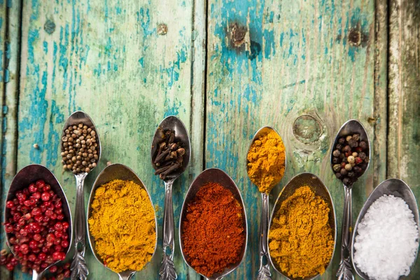 Diverse kleurrijke specerijen op houten tafel — Stockfoto