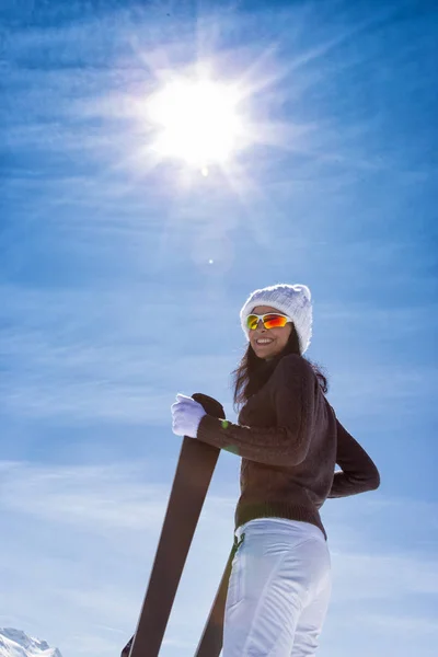 Красивая брюнетка с лыжами — стоковое фото