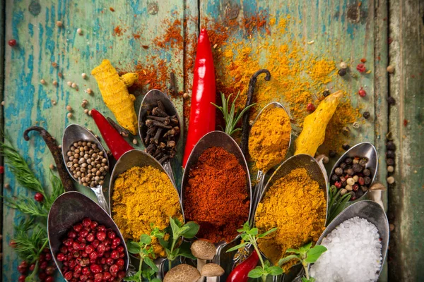 Diverse kleurrijke specerijen op houten tafel — Stockfoto