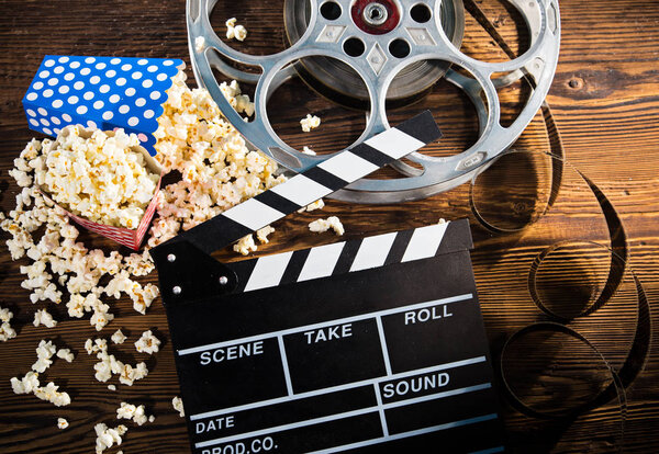 Cinema concept of vintage film reel with popcorn.