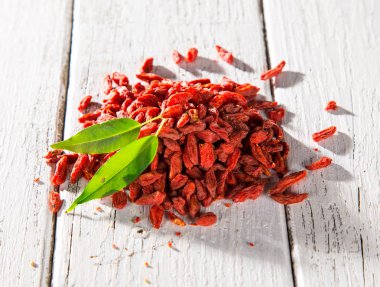 Eski Beyaz ahşap arka plan kuru goji berry.