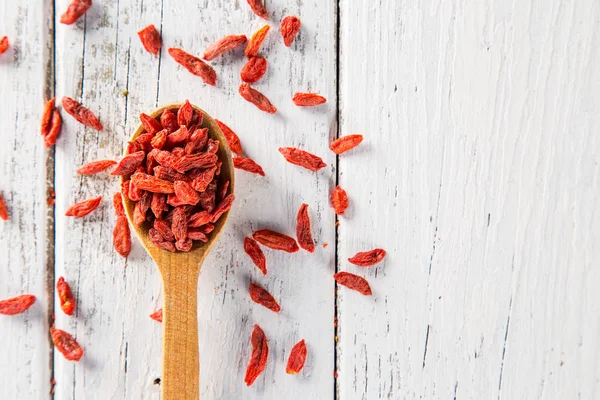 Baya de goji seca sobre fondo de madera blanca vieja . — Foto de Stock