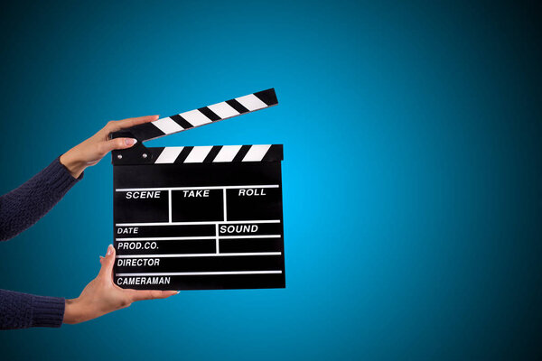Clapperboard sign hold by female hands.
