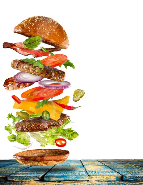 Big gustoso hamburger con ingredienti volanti . — Foto Stock