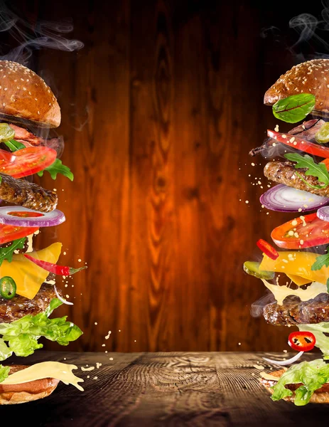 Big gustoso hamburger con ingredienti volanti . — Foto Stock