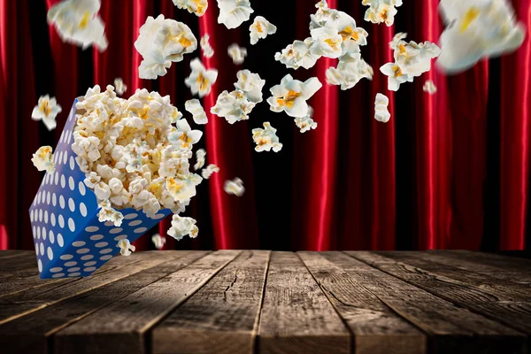 Popcorn exploze na starý dřevěný stůl. — Stock fotografie