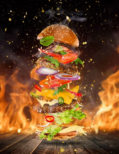 成分が飛んで大きなおいしいハンバーガー. — ストック写真