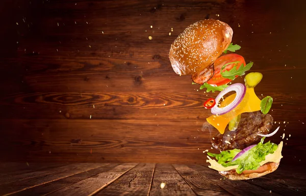 Gran hamburguesa sabrosa con ingredientes voladores . —  Fotos de Stock