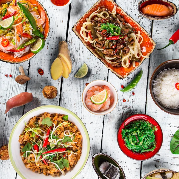 Různé asijské jídlo na rustikální pozadí, pohled shora, místo pro text. — Stock fotografie