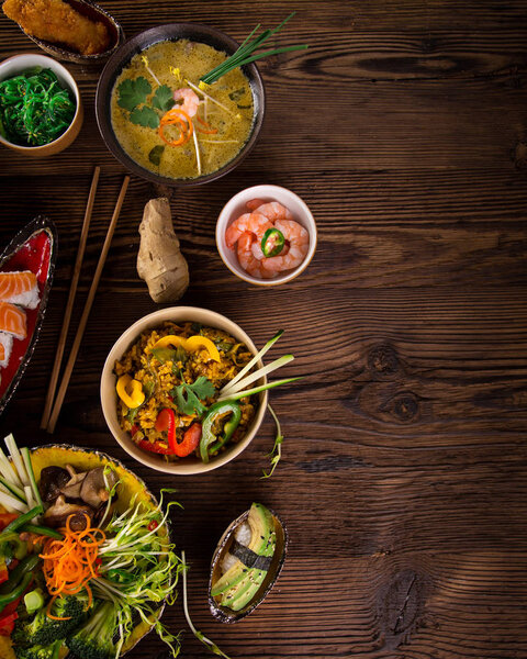 Различные азиатские блюда на деревенском фоне, вид сверху, место для текста
.