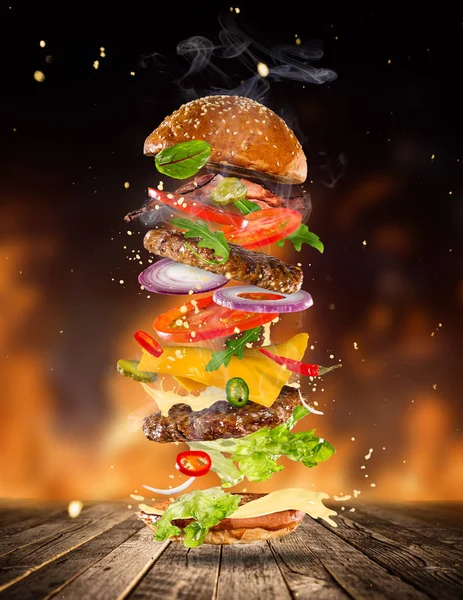 Großer leckerer Burger mit fliegenden Zutaten. — Stockfoto