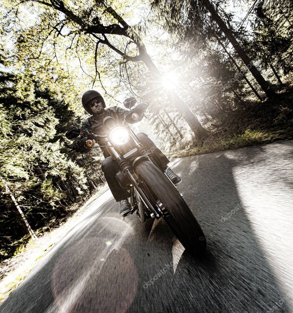 Close up of a high power motorcycle. Rider driving on forest road.