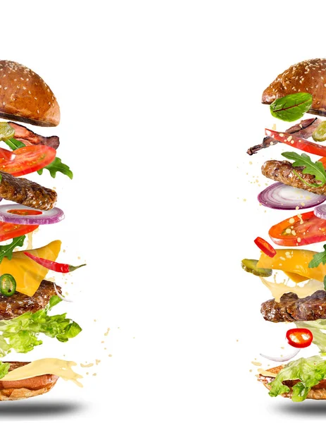 Big tasty burger with flying ingredients. — Stock Photo, Image