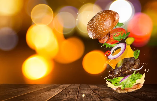 Grote smakelijke hamburger met vliegende ingrediënten. — Stockfoto