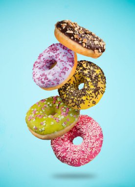Pastel mavi zemin üzerine düşen hareket lezzetli çörekler.