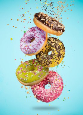 Pastel mavi zemin üzerine düşen hareket lezzetli çörekler.