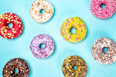 Pastel mavi zemin üzerine bonibon Donuts sırlı.