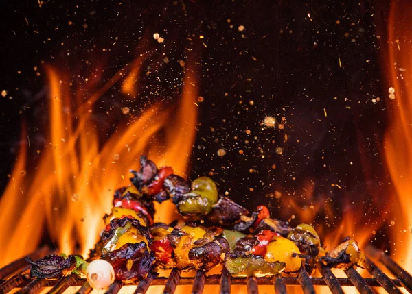 Chicken skewers on the grill with flames — Stock Photo, Image
