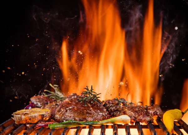 Bifes de carne na grelha com chamas — Fotografia de Stock