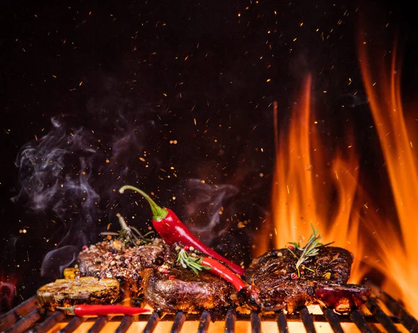 Steaks de boeuf sur le gril avec des flammes — Photo