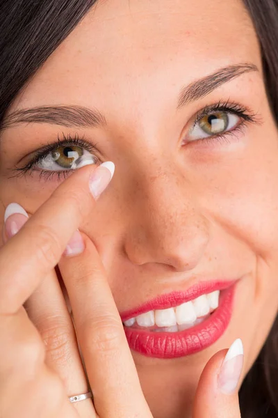 Jonge vrouw zetten contact lens in haar oog. — Stockfoto