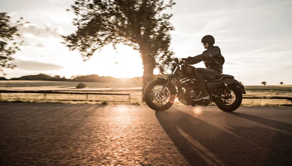 Mann fährt Sportster Motorrad bei Sonnenuntergang. — Stockfoto
