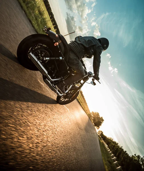 Hombre montando motocicleta deportiva durante la puesta del sol . — Foto de Stock