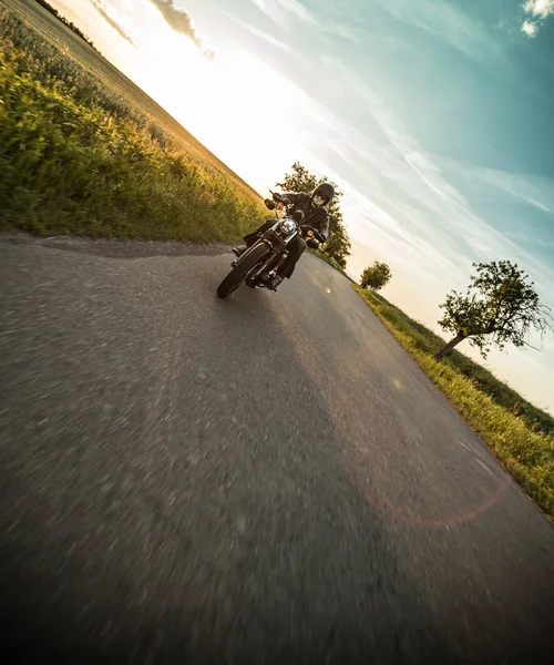 Man riding sportster motorcycle during sunset. — Stock Photo, Image