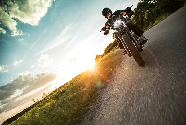 Hombre montando motocicleta deportiva durante la puesta del sol . — Foto de Stock