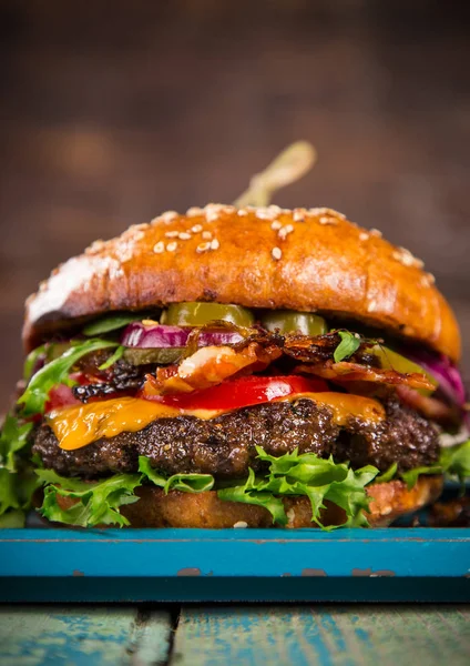 Stora läckra burger serveras på gamla träbord. — Stockfoto