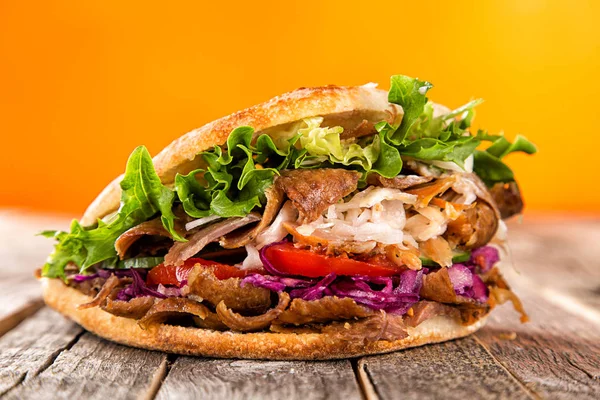 Close up of kebab sandwich on old wooden table. — Stock Photo, Image