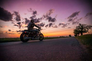 Günbatımı sırasında kişini Sportster motosiklet.