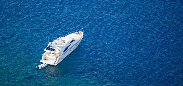 Barco em águas azuis profundas, Santorini, Grécia . — Fotografia de Stock