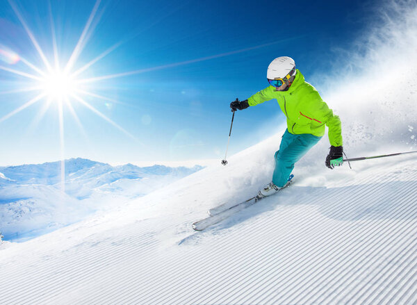 Skier skiing downhill in high mountains