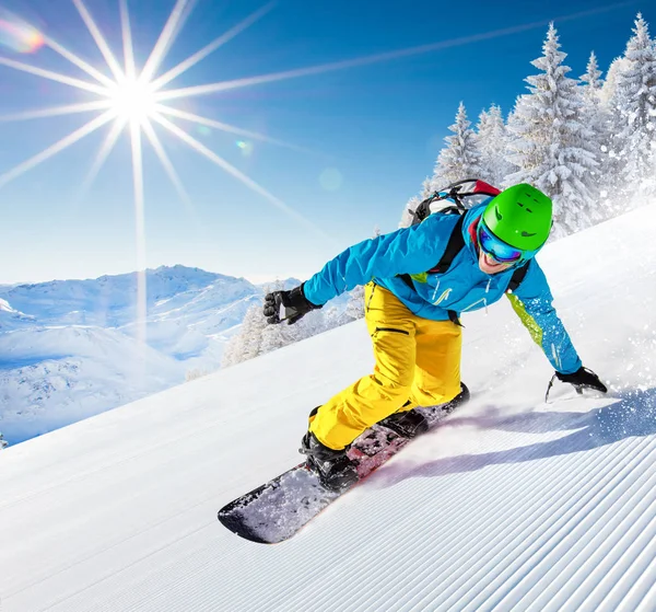 Yüksek dağlarda kayakçı yokuş aşağı gidiyor.