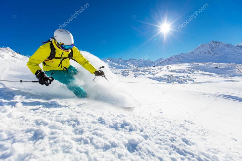 Skier skiing downhill in high mountains