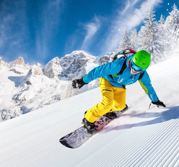 Yüksek dağlarda kayakçı yokuş aşağı gidiyor.