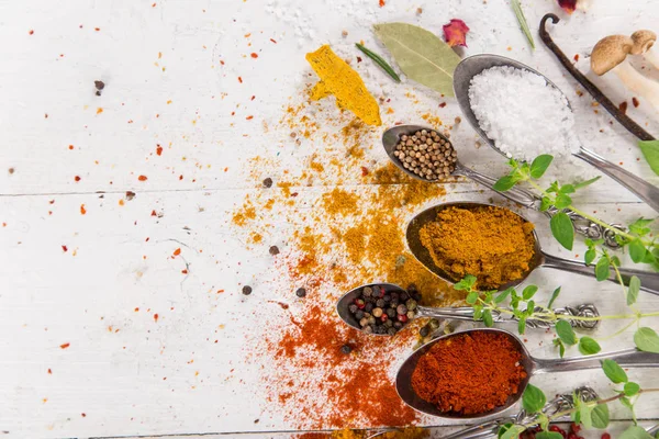 Ahşap masada çeşitli renkli baharatlar var.