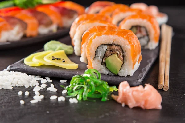 Sushi japonés ambientado sobre un fondo rústico oscuro . —  Fotos de Stock