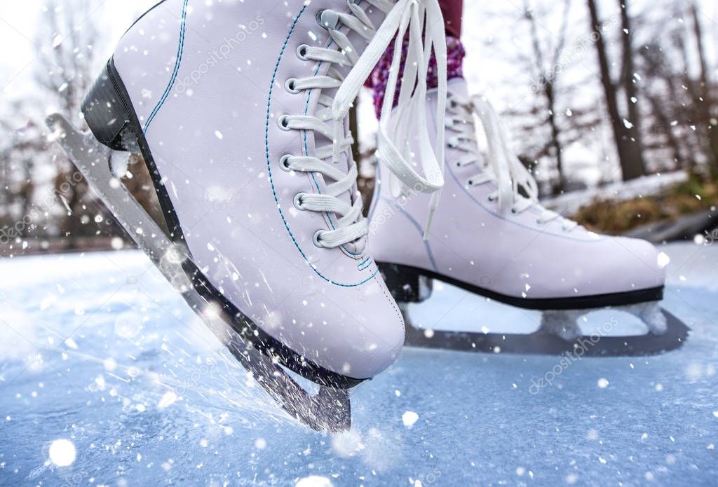 Close-up of woman ice skating on a pond.