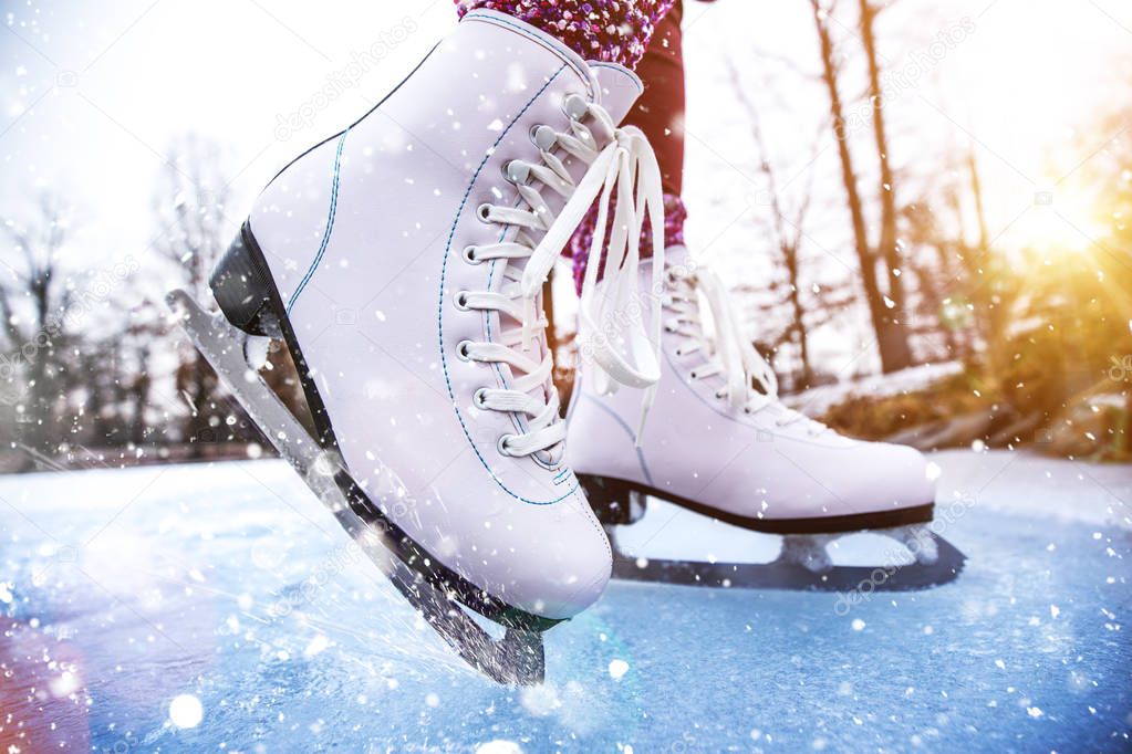 Close-up of woman ice skating on a pond.