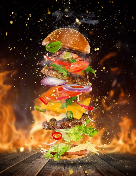 Big gustoso hamburger con ingredienti volanti . — Foto Stock