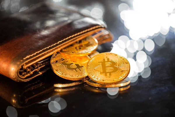 Золотые монеты биткойна с бумажником. Концепция виртуальной криптовалюты. — стоковое фото