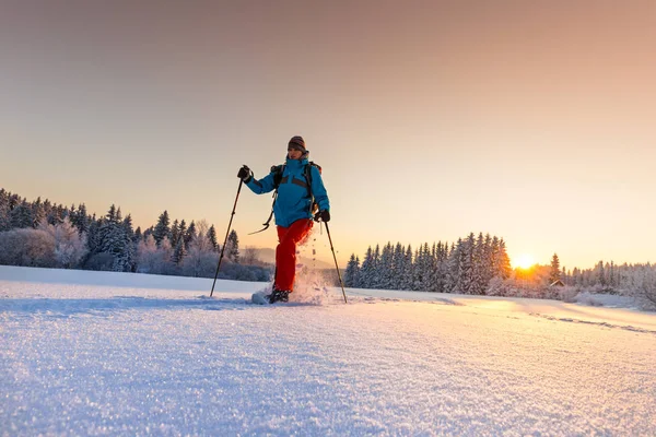 Сонячний зимовий пейзаж з людиною на снігоступах . — стокове фото