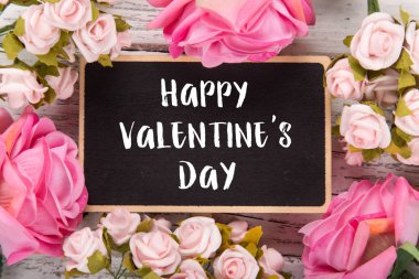 Sevgililer günü için küçük kara tahta. Arka plan ile pembe güller.