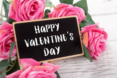 Sevgililer günü için küçük kara tahta. Arka plan ile pembe güller.