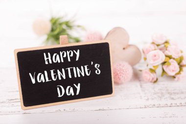 Sevgililer günü için küçük kara tahta. Arka plan ile pembe güller.