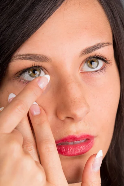 Junge Frau setzt Kontaktlinse ins Auge. — Stockfoto